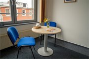 Ein Besprechungstisch mit Blumen und Flyern im Autismus-Zentrum Rostock